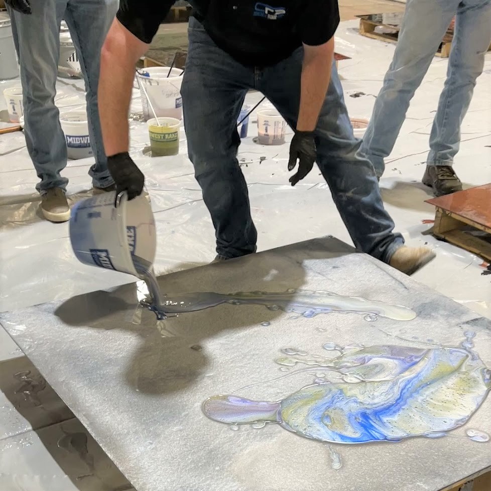 A man using a drill to work on a painting.