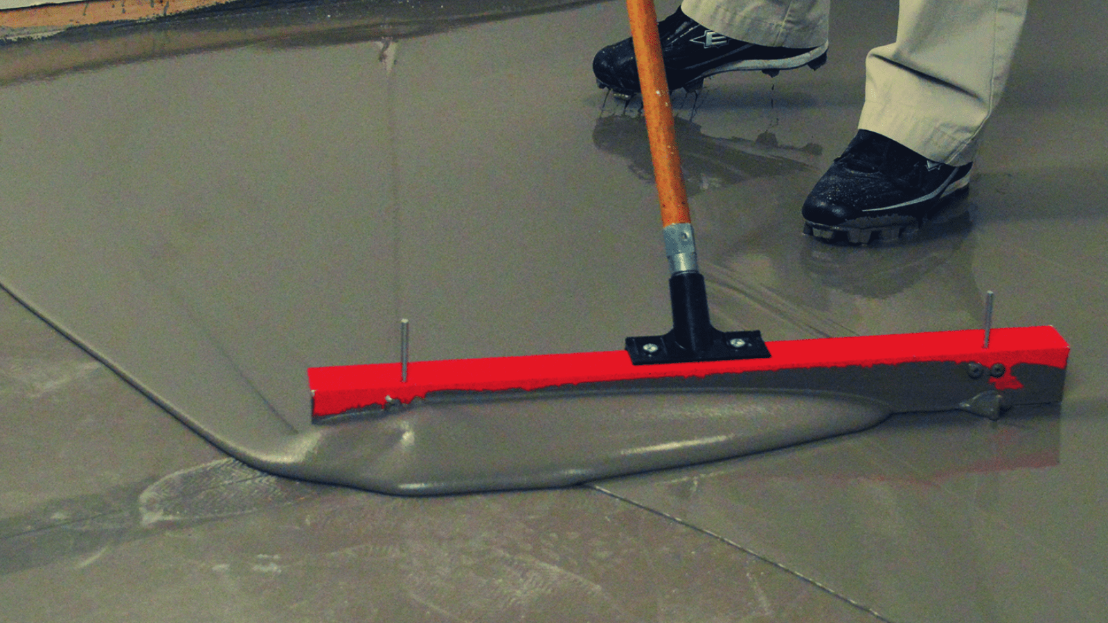A man is sweeping the floor with a broom.