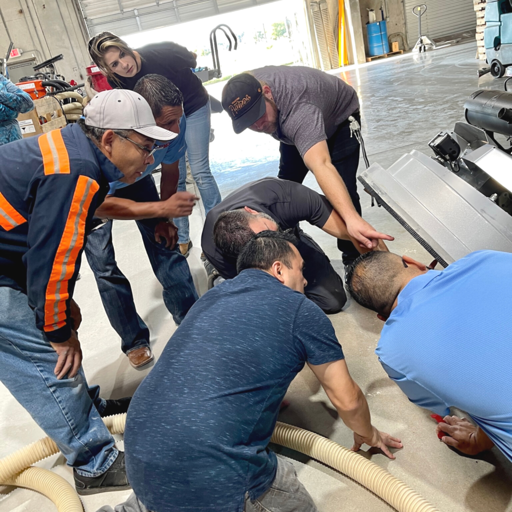 A group of men working on pipes in an industrial setting.