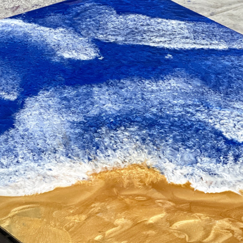 A blue and white rug with sand on it