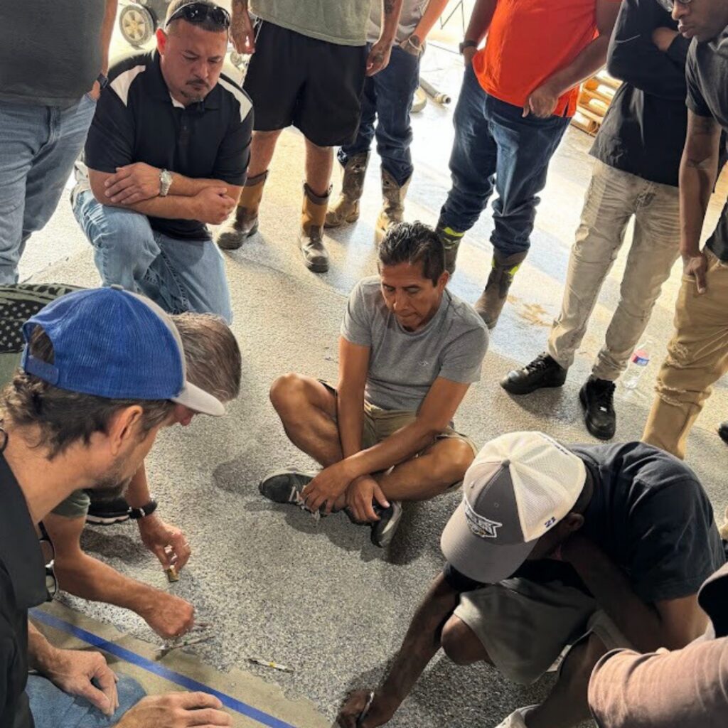 A group of people sitting and kneeling on the floor, engaged in a discussion or activity.