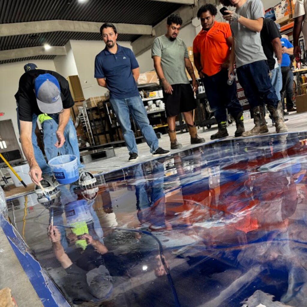 People observing a large, detailed floor map in an indoor setting.