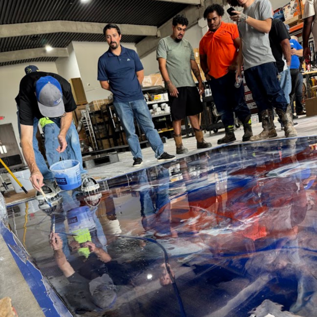 People observing a large, detailed floor map in an indoor setting.