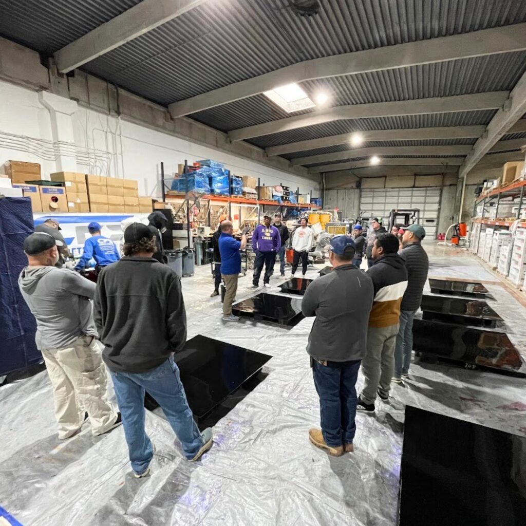 Group gathered in warehouse workshop for a demonstration.